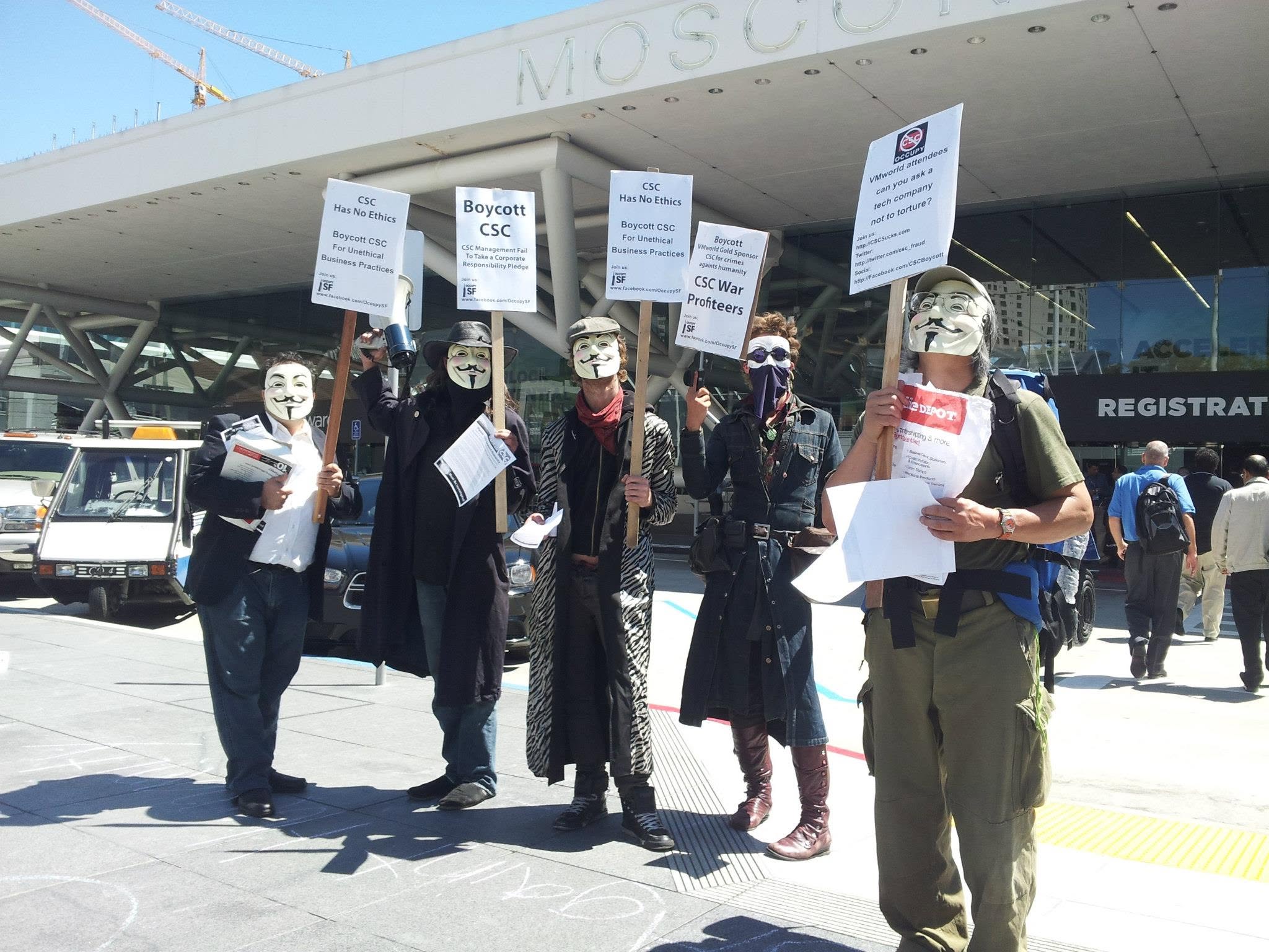 Occupy San Francisco protesters holding Boycott CSC War Profiteers signs outside Moscone Center